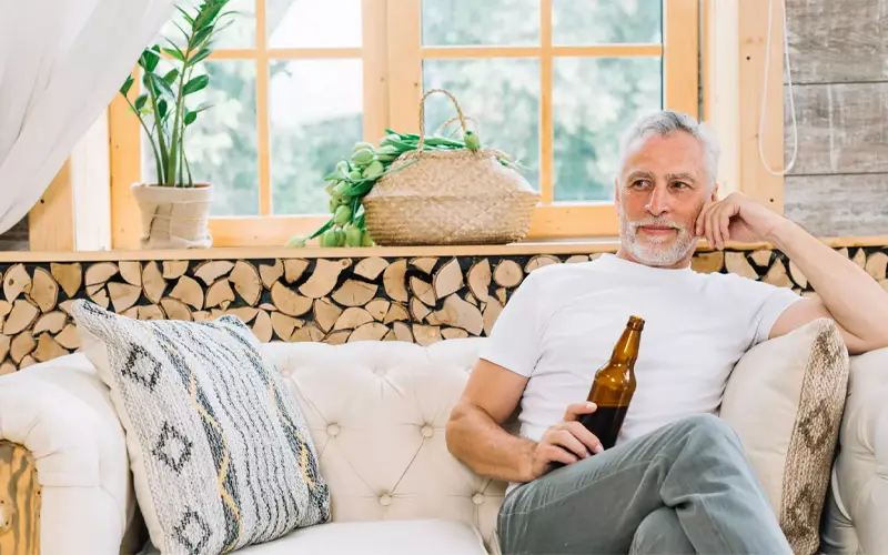 white haired man enjoying beer